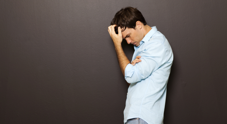 man standing with his head in his hands