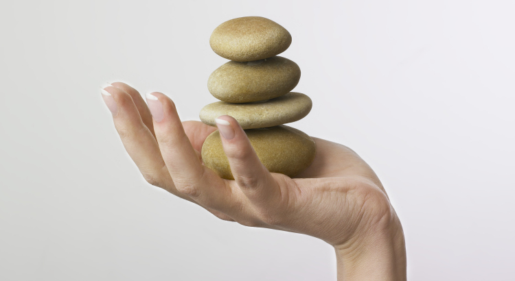 Hand holding 4 zen stones